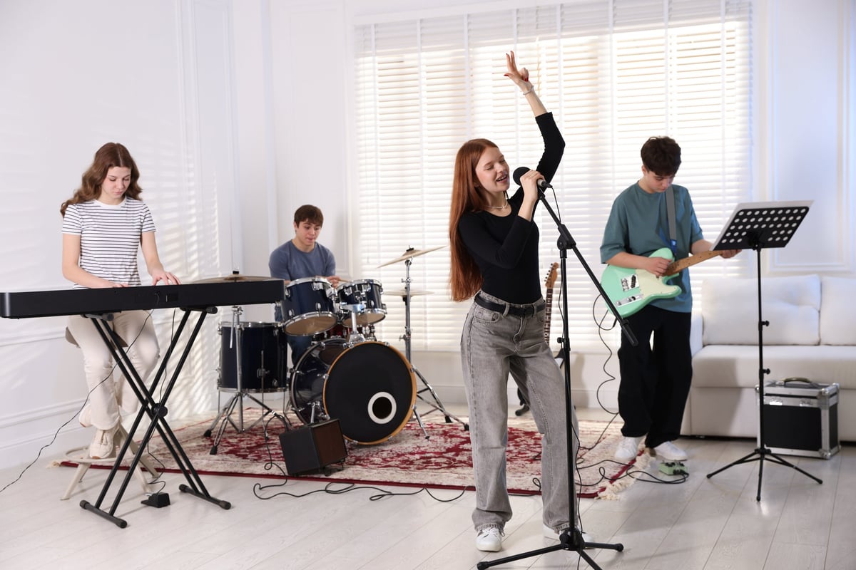 Teenage music band practicing their performance indoors